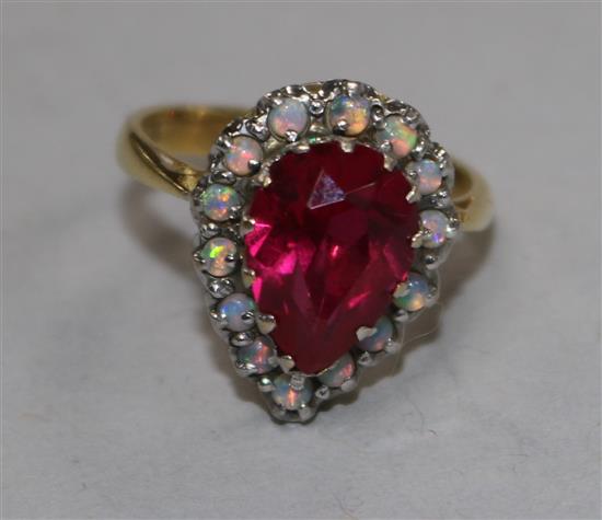 An 18ct gold, pear shaped synthetic ruby and white opal cluster dress ring, size L.